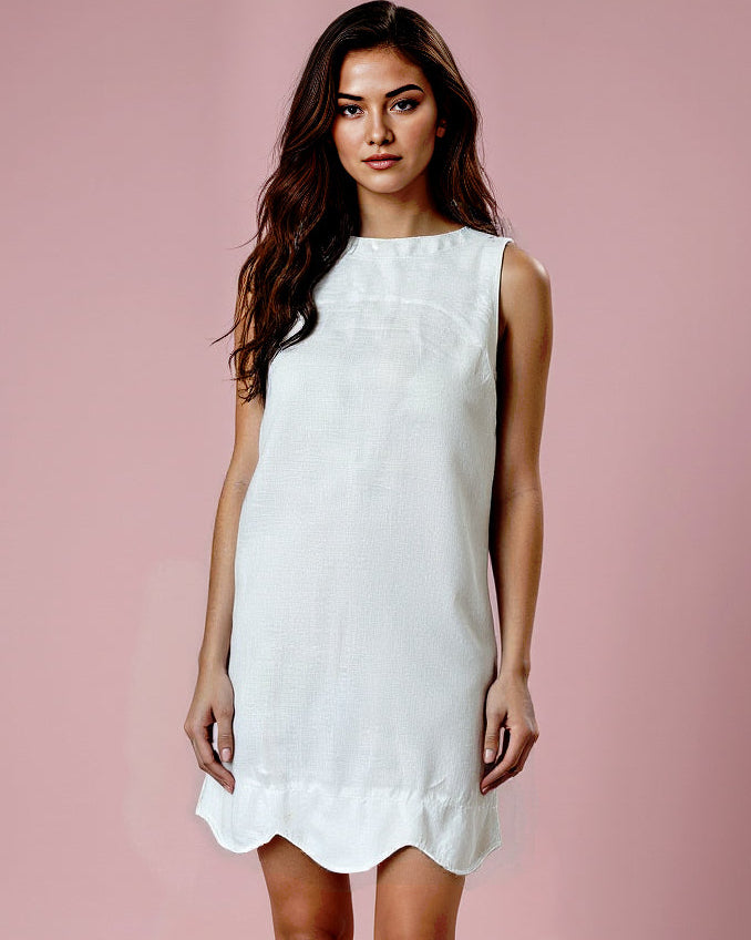 Woman wearing a white dress against a pink background